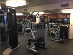 A strength training machine with other matrix fitness equipment in a fitness room