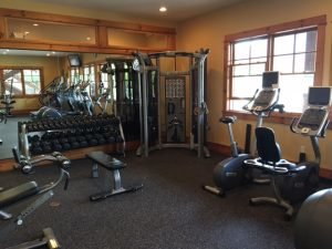 A fitness room with mirrors reflecting fitness equipment