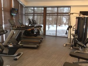 A snowy field outside of a room with commercial fitness equipment