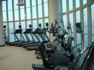 A curved windowed area with ellipticals treadmills and bikes lined up against it