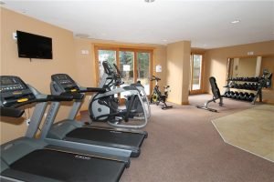 Treadmills, ellipticals bikes and weights in an open fitness room