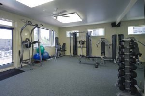 A fitness room with mirrors on one wall