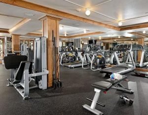 A mirrored fitness training room with treadmills and ellipticals