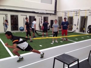 A man using a resistance training bungee cord while people watch