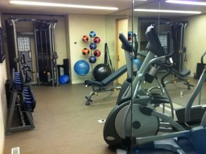 A room with a glass wall and residential fitness equipment