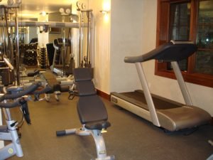 A wood-framed window sits in the front of a fully featured work out room