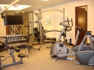 An elliptical and bike in a mirrored residential fitness room