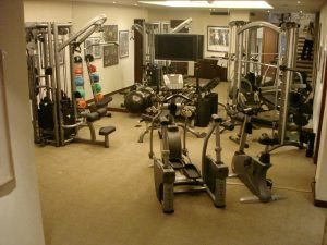 A mirrored residential fitness room with colorful ball weights