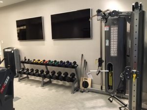 Two televisions above a weight lifting area