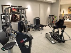 A residtential fitness room next to a living room