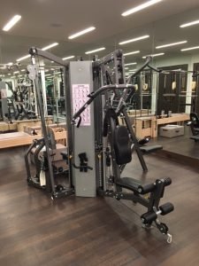 A 3 sided weight lifting machine in a mirrored room