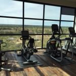 4 pieces of cardio equipment looking outside a window.