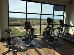 4 pieces of cardio equipment looking outside a window.