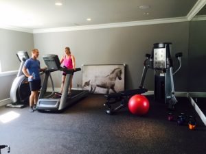 A man and woman using residential treadmills in a fitness room