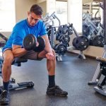 A man doing curls on a weight bench