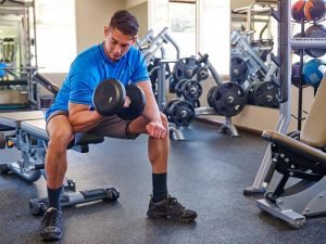 A man doing curls on a weight bench